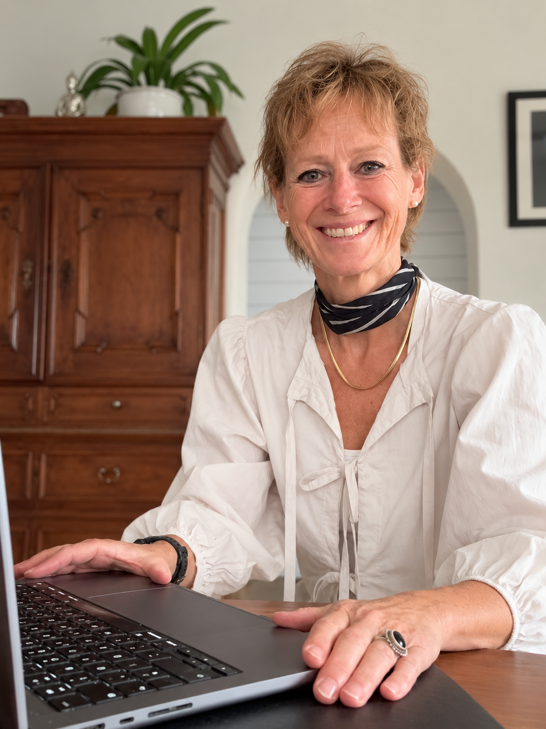 Heike Boschmann sitzt lächelnd an ihrem Laptop